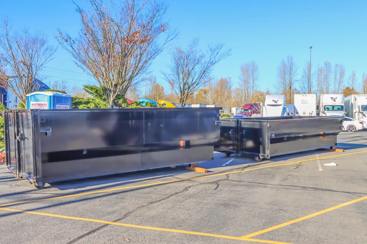 Professional dumpster rental service with roll-off container on residential driveway in New Kingman-Butler